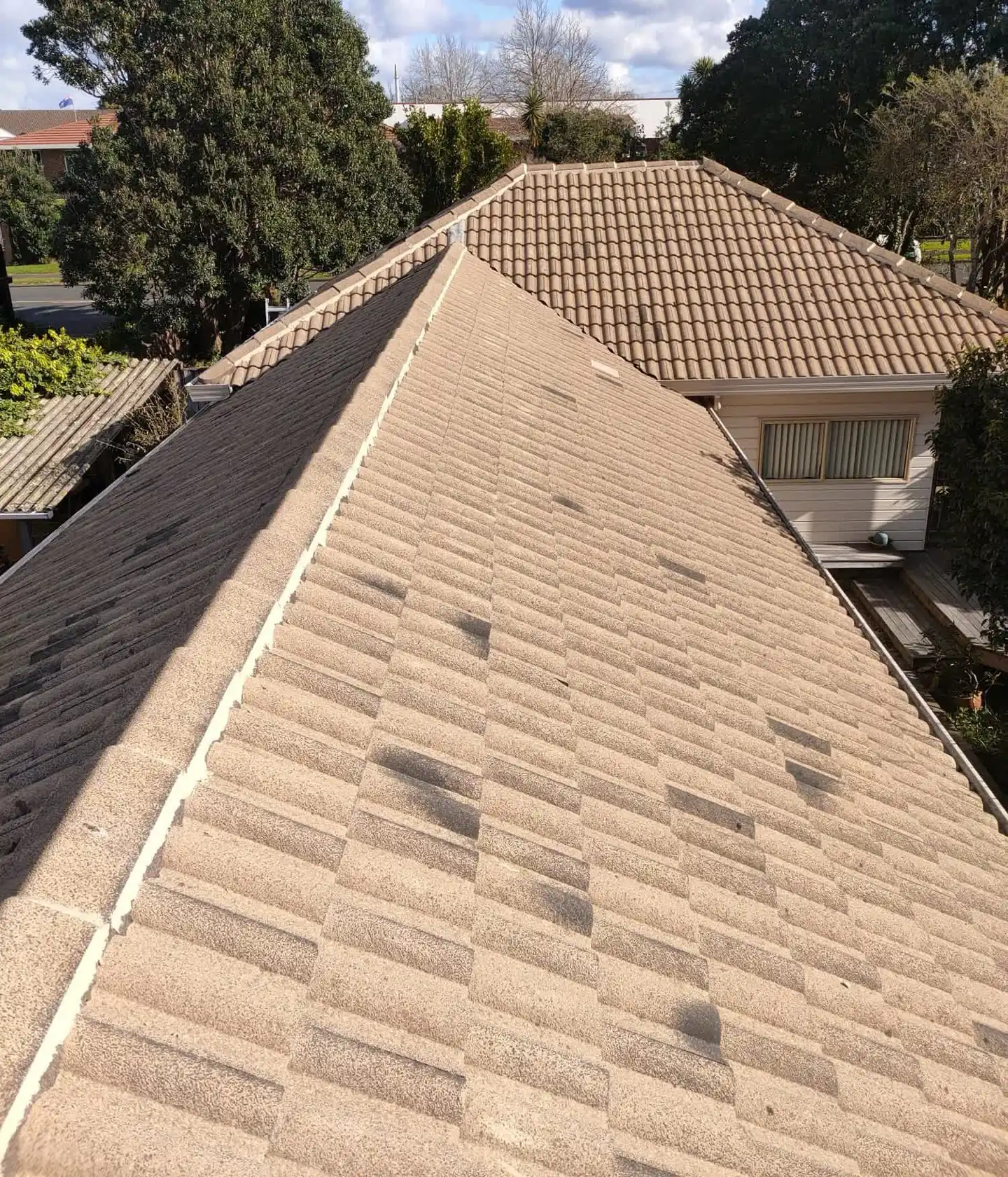 Faded concrete tile roof seen from the ridge, before cleaning or recoating